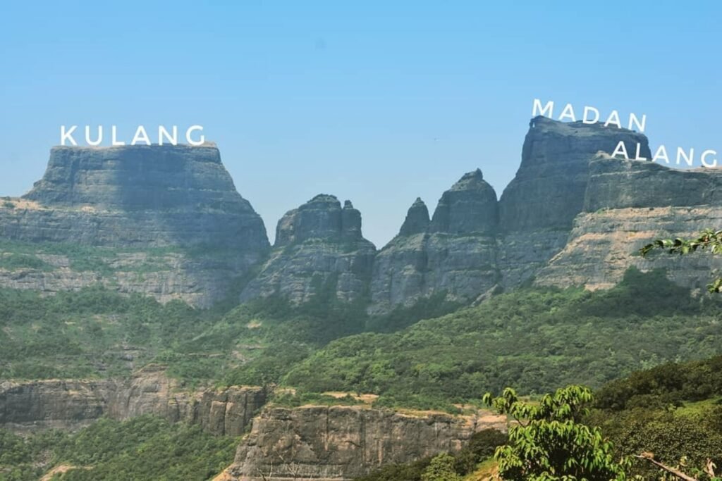 Treks Near Nashik featuring the dramatic rock formations of Alang, Madan, and Kulang Forts under a clear blue sky.