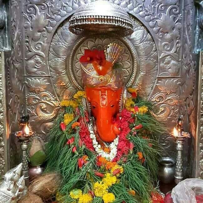 Ganpati Festival in Nashik with beautifully decorated Ganesha idol, flowers, and traditional silver backdrop