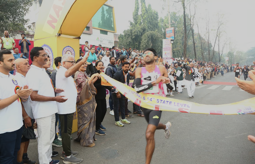 Marathon runner crossing the finish line at a state-level event, symbolizing the growth of Sports in Nashik 2025 with strong community support.