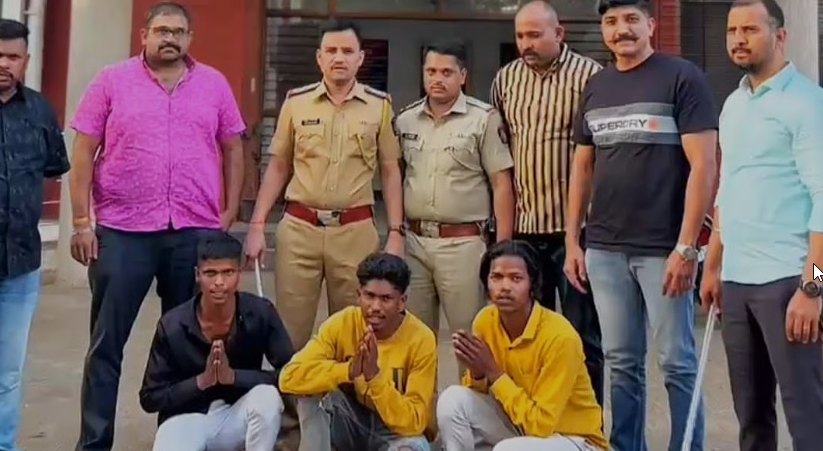 Nashik Police Viral Videos 2025 – Police officers pose with three detained young men kneeling in front, hands folded, in front of a police station after an arrest operation.