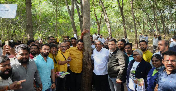 Citizens and activists gathering around a tree in Tapovan forest to protest against the Tapovan Tree Cutting issue in Nashik, highlighting unity to save over 1,700 trees